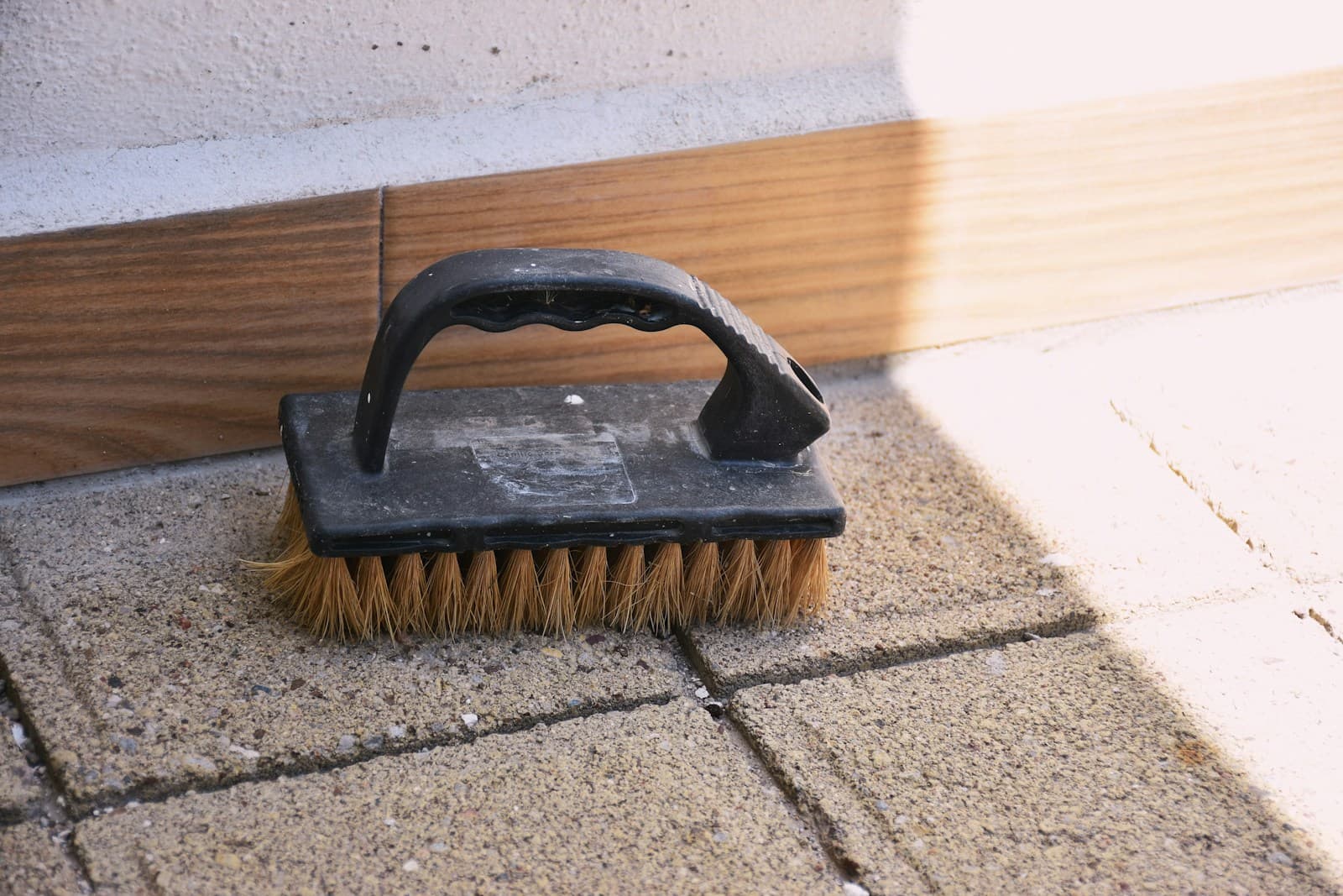 Escova de cerda dura sobre piso intertravado — alternativa manual usada em pequenos pontos ou áreas que a enceradeira não alcança